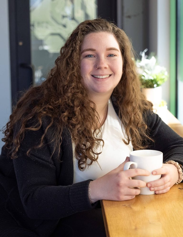 Image of Digital Marketing Specialist, Destiny Harvel, holding a coffee mug, at Paradigm Digital Group offices