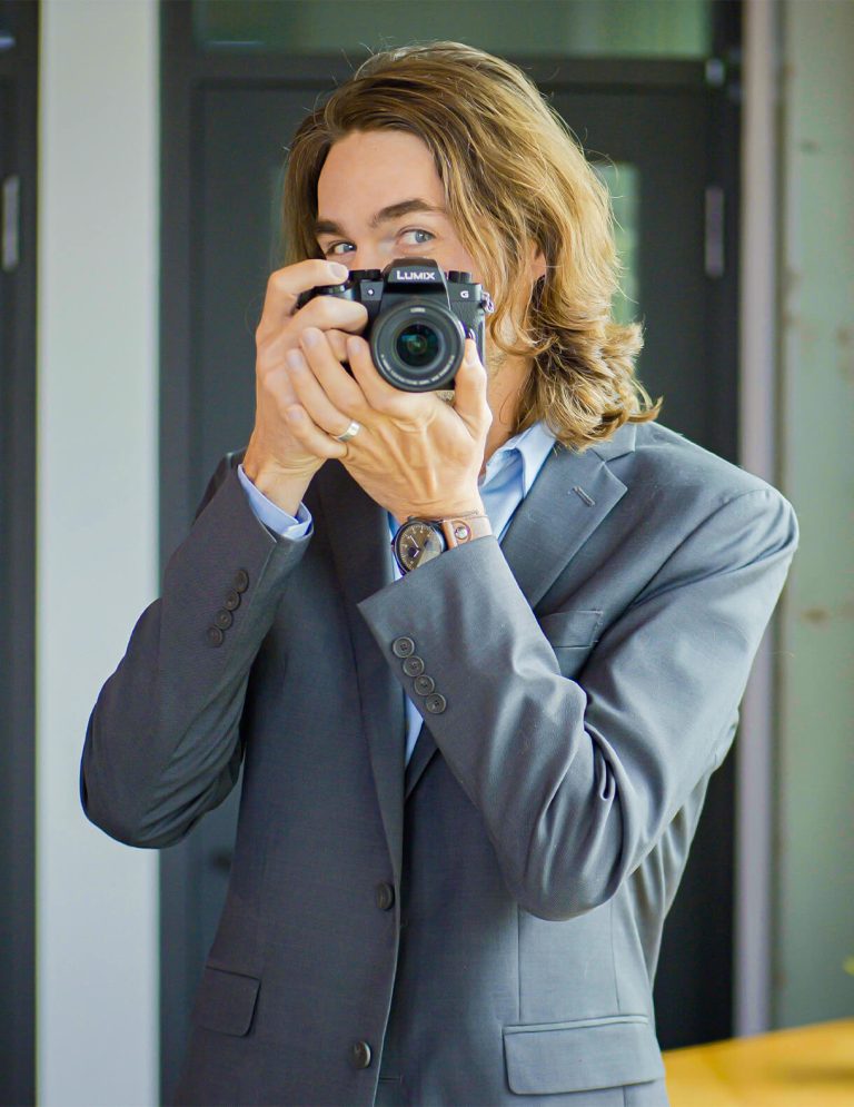 Image of Videographer and Editor, Evan Castor, pointing a camera at Paradigm Digital Group offices