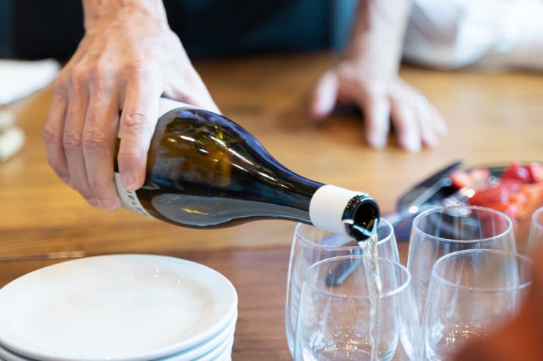 Image of Wine Sommelier Bob Newman pouring wine into tumbler glass during Wine Friday segment, a popular part of Paradigm Digital Group's company culture